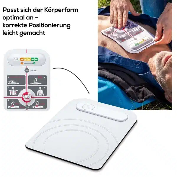 Eine Person verwendet eine kabellose, weiße Beurer LifePad® Reanimationshilfe der Marke innotas an einer Puppe und demonstriert die richtige Handhaltung. Eine Anleitung zeigt die Vorgehensweise Schritt für Schritt. Das Gerät zeigt zur Orientierung Körperkonturen an.