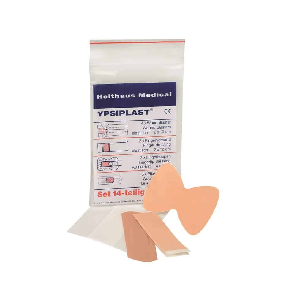 Abgebildet ist eine Packung Holthaus Medical YPSIPLAST® Pflasterset, DIN der Holthaus Medical GmbH & Co. KG. Das 14-teilige Set beinhaltet 4 Wundpflaster (6 x 10 cm), 2 Fingerkuppen- und Fingerverbände, 2 Schmetterlings-Wundpflaster und 6 kleine Heftpflaster. Einige der Artikel sind außerhalb der Packung abgebildet.