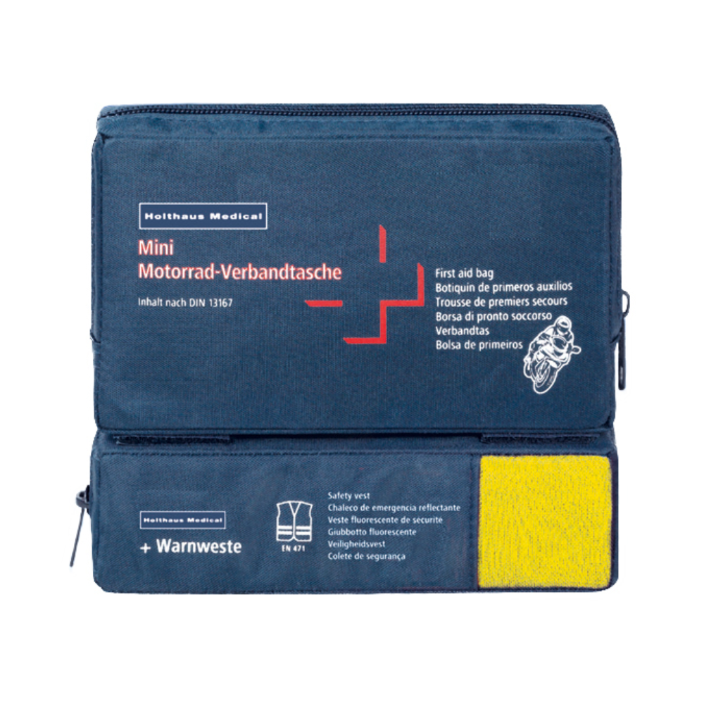 Ein blaues Erste-Hilfe-Set mit der Aufschrift „Holthaus Mini Combi Verbandtasche Motorrad“ von Holthaus Medical GmbH & Co. KG mit mehrsprachigem Text für Motorräder. Es entspricht der DIN 13167 und enthält eine durch einen transparenten Abschnitt sichtbare Warnweste. Die Mini Combi Verbandtasche verfügt über zwei Reißverschlussfächer – eines oben und eines an der Seite.