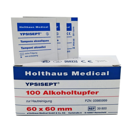 Abbildung einer Schachtel Holthaus Medical GmbH & Co. KG Holthaus Ypsisept® Alkoholtupfer 60 x 60 mm, 100 Stück | Packung (1 Stück). Die Box enthält den Text „100 Alkoholtupfer zur Hautreinigung“ und „60 x 60 mm“. Hinter der Box stehen mehrere einzelne Isopropylalkohol-Tupferpäckchen.