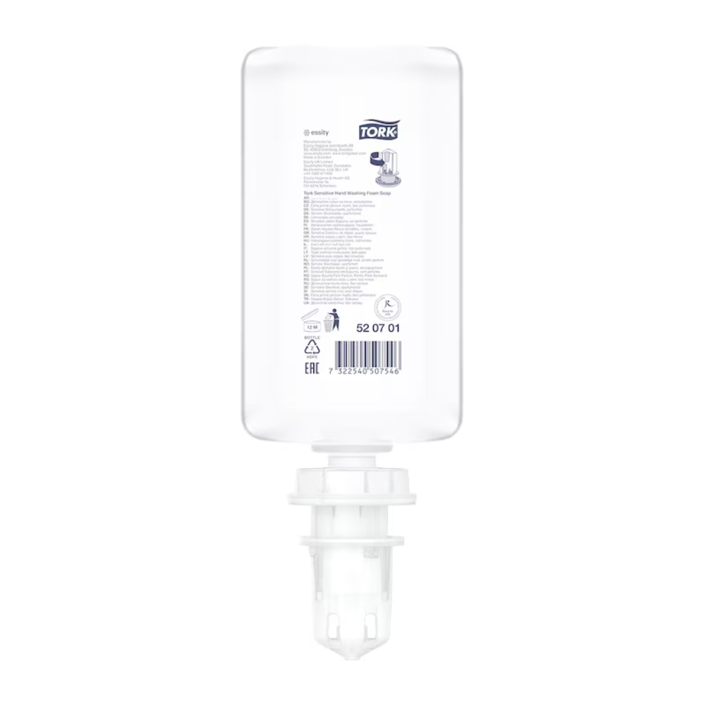 Eine durchsichtige, rechteckige Plastikflasche mit der Aufschrift „Tork 520701 Sensitive Hand-Schaumseife Premium S4 | Karton (6 Flaschen)“ mit Produktdetails und Anleitung in schwarzem und grauem Text. Die Flasche hat unten einen weißen Pumpmechanismus, der auf ihre Verwendung als Spender hinweist, wahrscheinlich für allergikerfreundliche Seife oder Desinfektionsmittel.