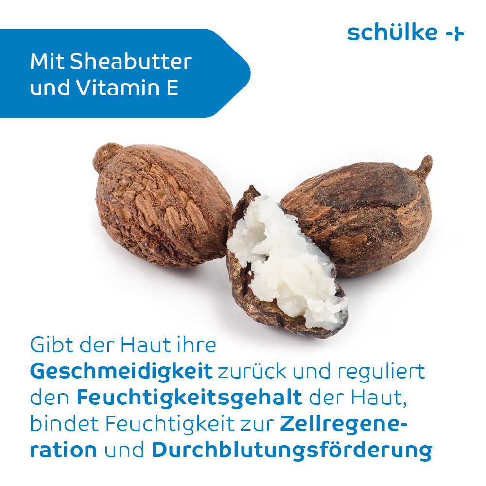 Drei Sheanüsse, von denen eine aufgeschnitten ist und ihr cremiges Inneres freigibt, stehen zentriert auf einem weißen Hintergrund. Der Text in deutscher Sprache hebt die Vorteile von Sheabutter und Vitamin E für Hautglätte, Feuchtigkeitsversorgung, Zellregeneration und Durchblutung hervor – eine perfekte Mischung für Schülke & Mayr GmbH Schülke esemtan® dry skin balm, Körperpflege-Balsam – 500 ml | Flasche (500 ml).